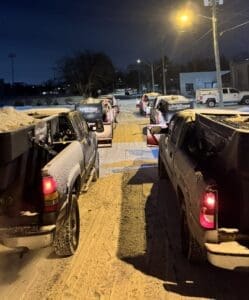 Fort Wayne ice control salt trucks lined up for commercial snow removal at night.