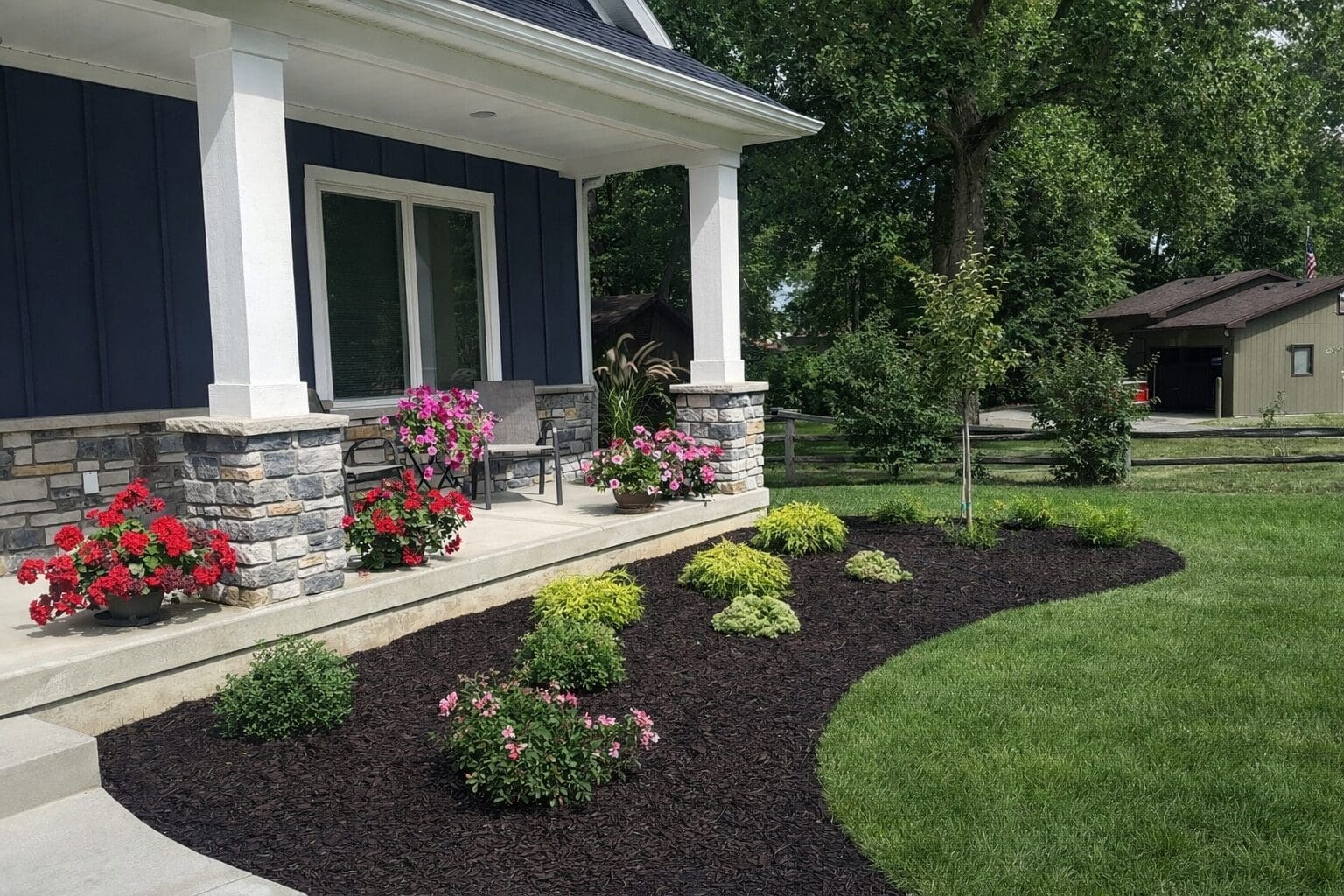 Fort Wayne Front yard landscaping with mulch garden bed, shrubs, flowers, and porch curb appeal.
