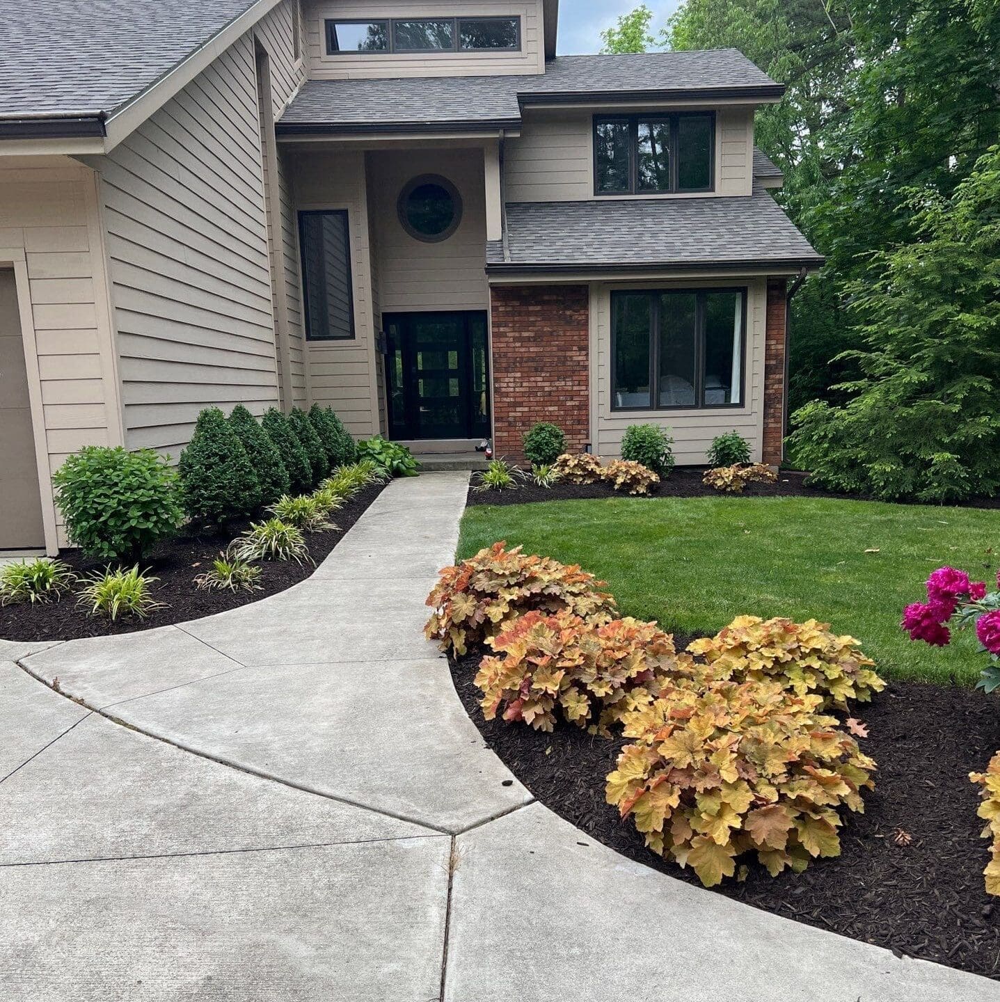 Fresh mulch landscaping along front walkway of Fort Wayne suburban home curb appeal.
