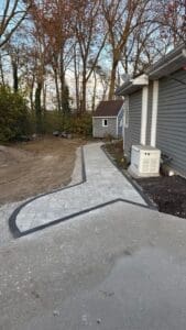 Backyard patio project under construction with partially installed pavers