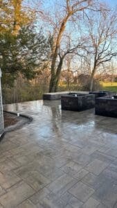 Backyard outdoor living area with completed paver patio and landscaping in Fort Wayne