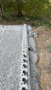 Installing custom pavers during backyard patio construction project